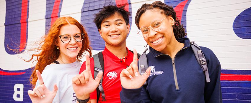 三名南阿拉巴马州的学生举着代表美洲虎的J标志.